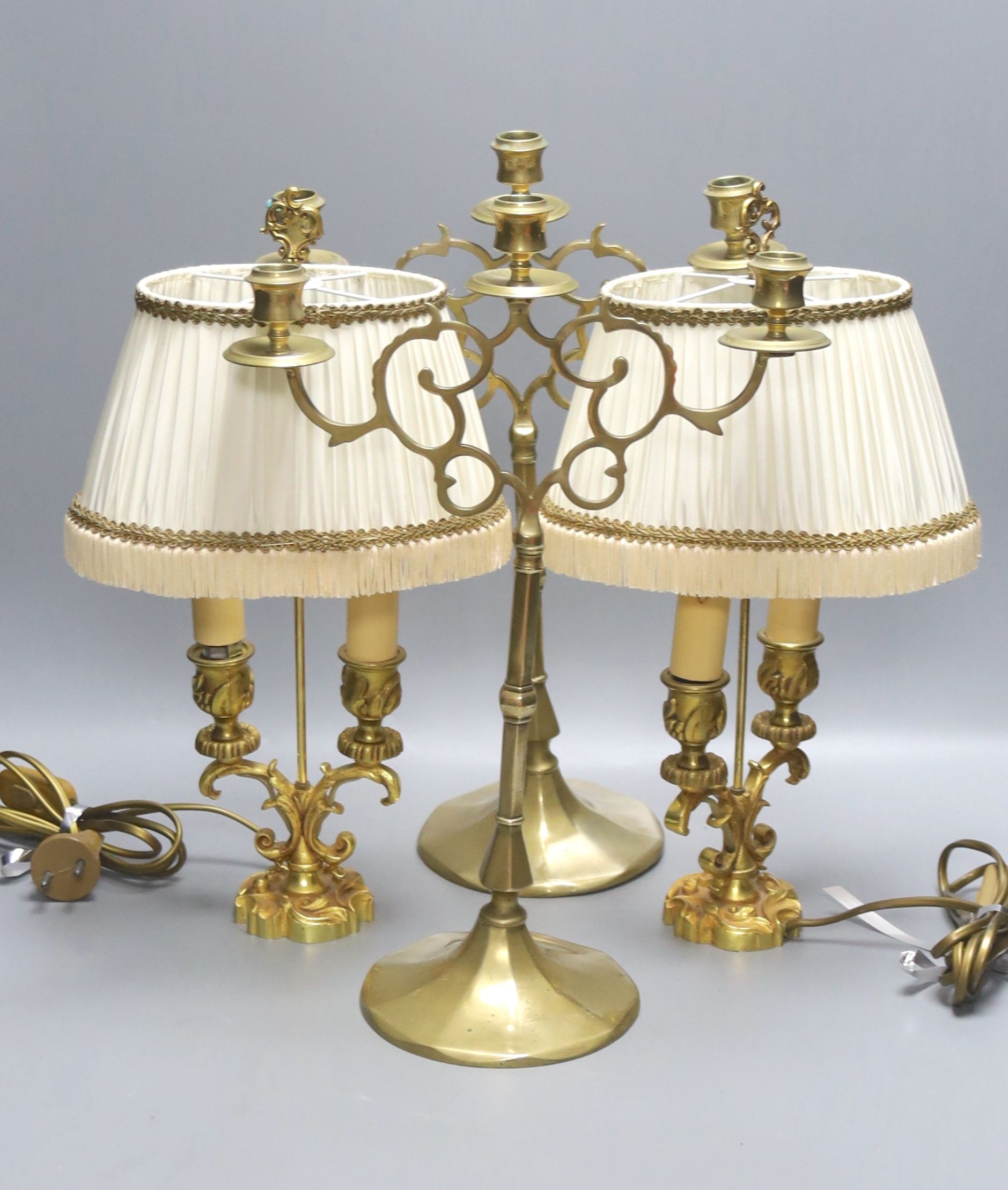 A pair of 19th century brass three branch candlesticks and a pair of twin branch table lamps, tallest 40cm